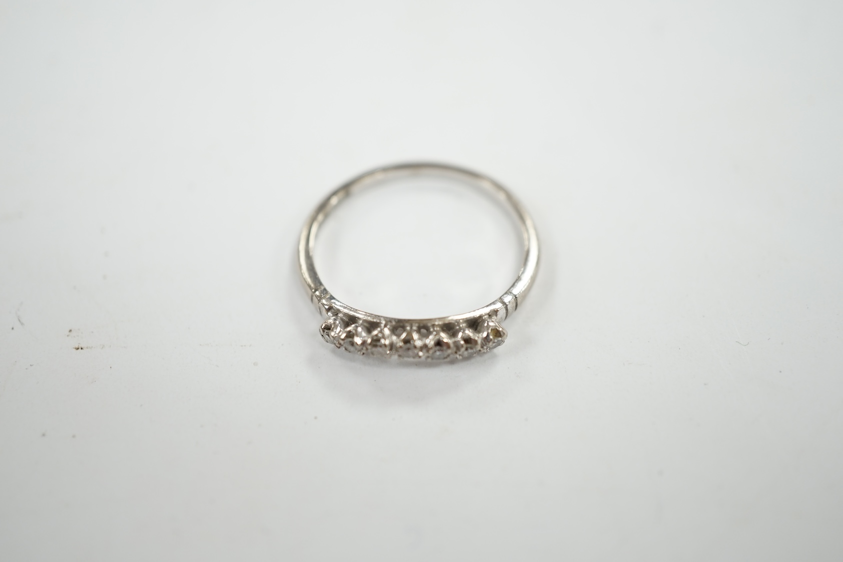 An 18ct, plat and seven stone diamond chip set 'chevron' half hoop ring, size O, gross weight 2.5 grams. Condition - fair